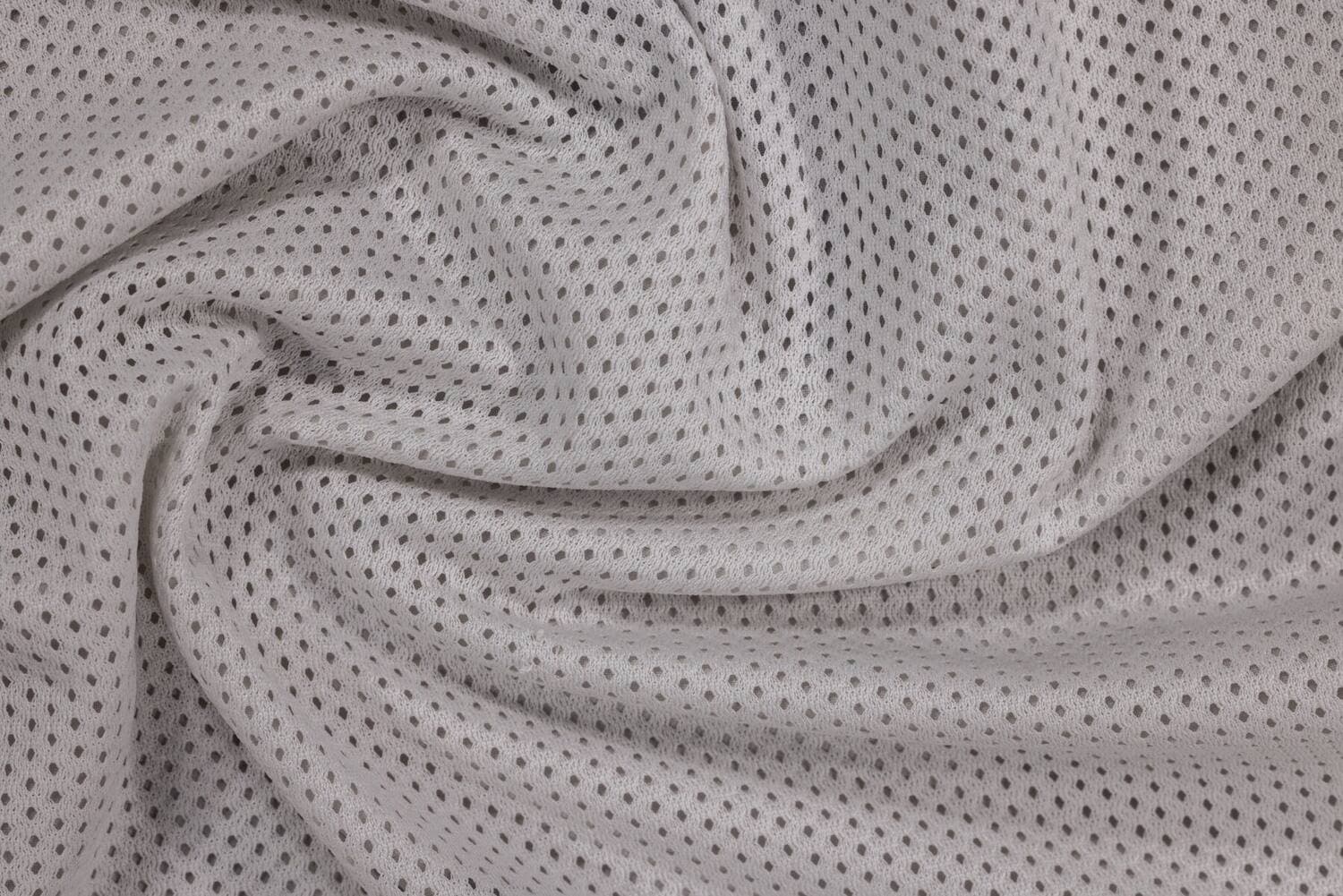 Un tessuto tecnico a maglia traforata, grigio chiaro, in primo piano